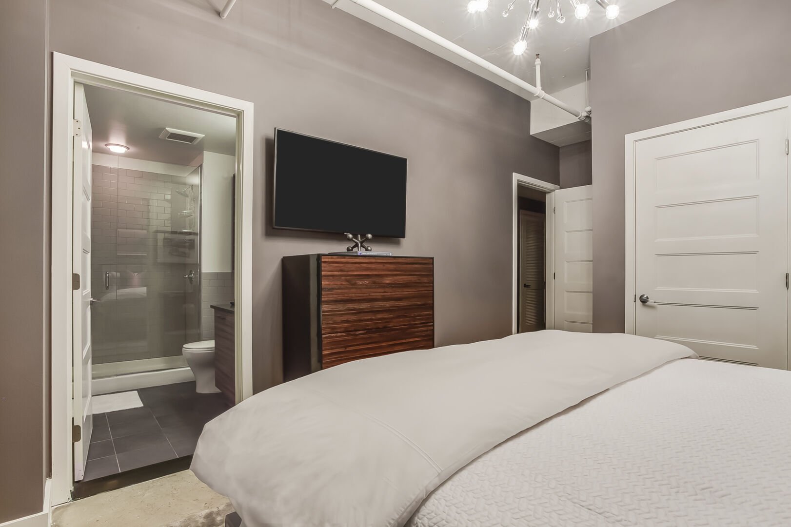 Master Bedroom with King Bed, TV, Dresser, and Ensuite Bathroom
