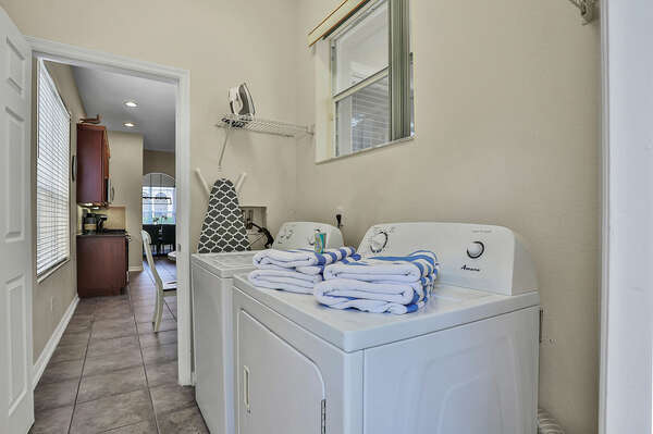 The laundry room has a washer, dryer, and ironing board