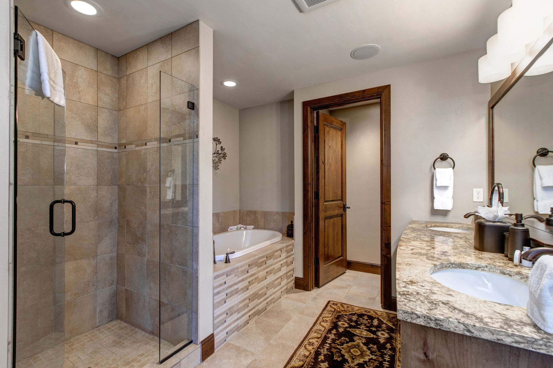 Private Master Bathroom with Jetted Tub, Large Tiled Shower, Dual Sinks, and separate wash closet