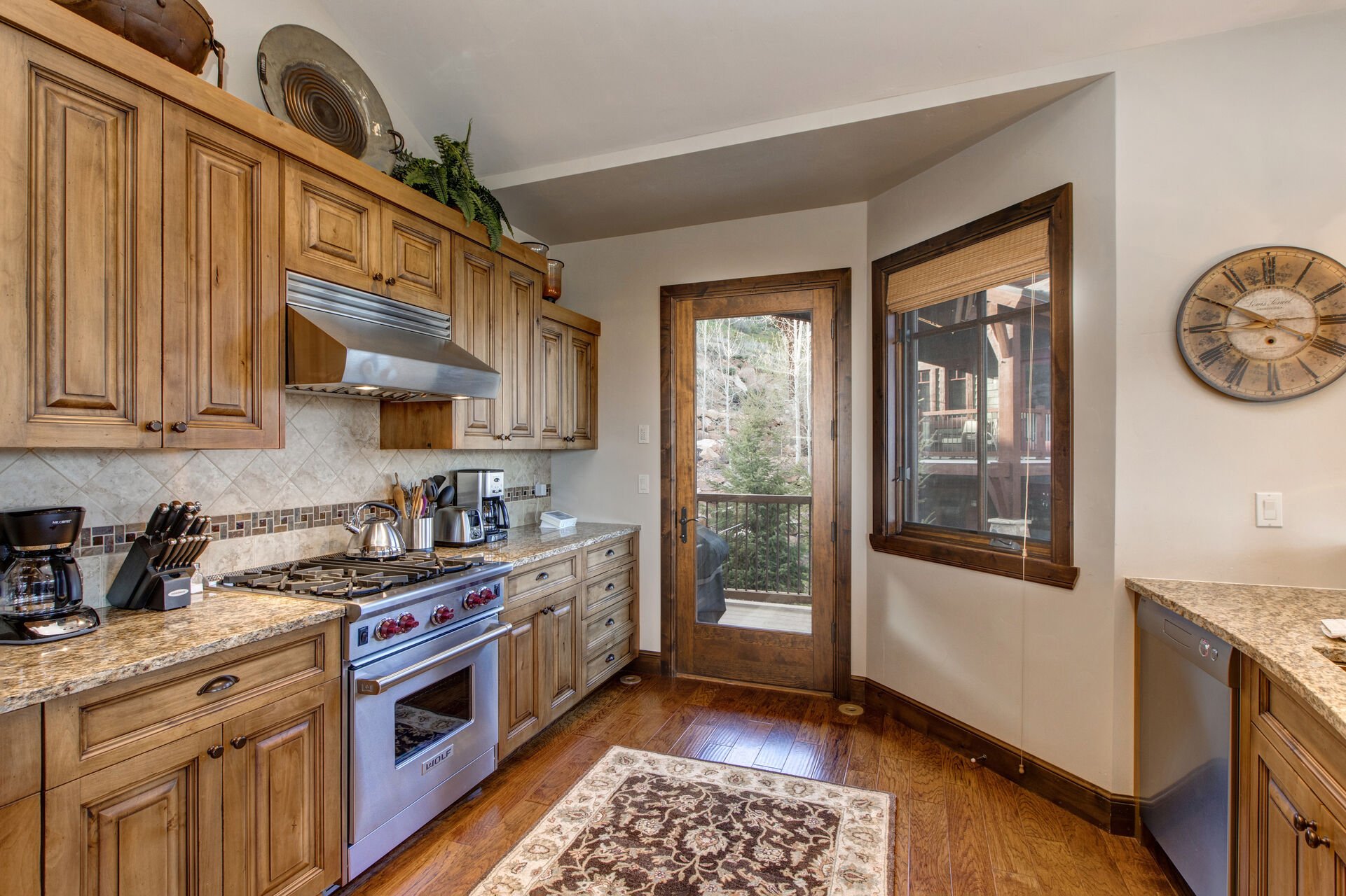 Fully Equipped Kitchen with Stainless steel, high-end appliances, Sub-Zero Fridge, Bar Seating for 3, Granite Countertops, and Private Porch access with BBQ Grill.