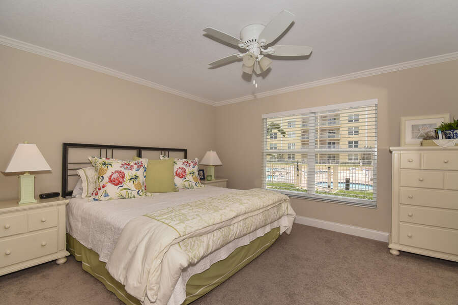 Large bed, nightstands, ceiling fan, and dresser
