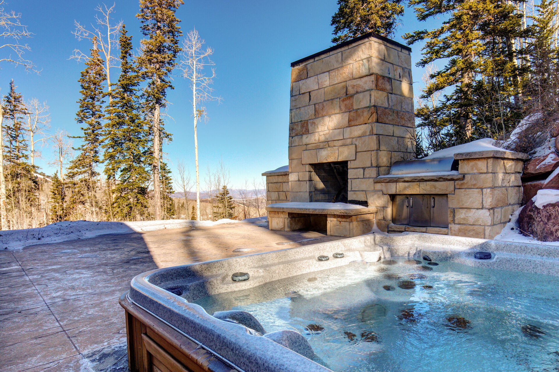 Large outdoor fireplace, private hot tub, and grilling area