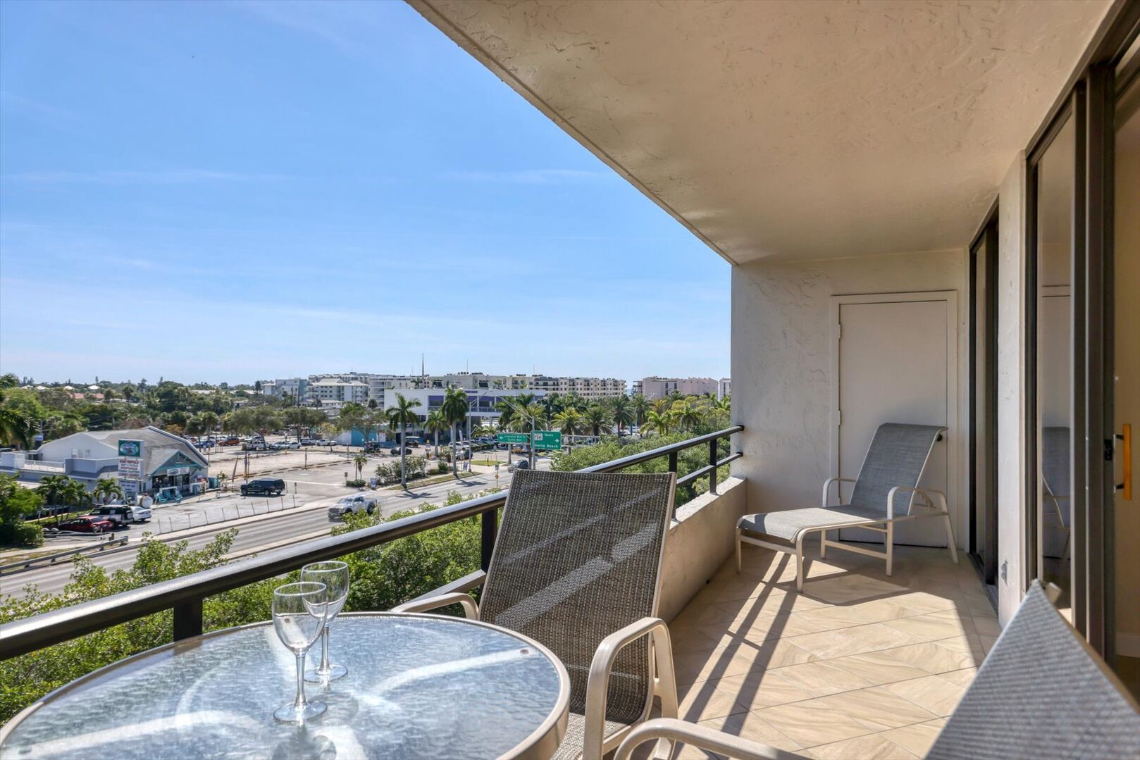 Large balcony with outdoor dining and lounge chairs for soaking up the Florida sun!