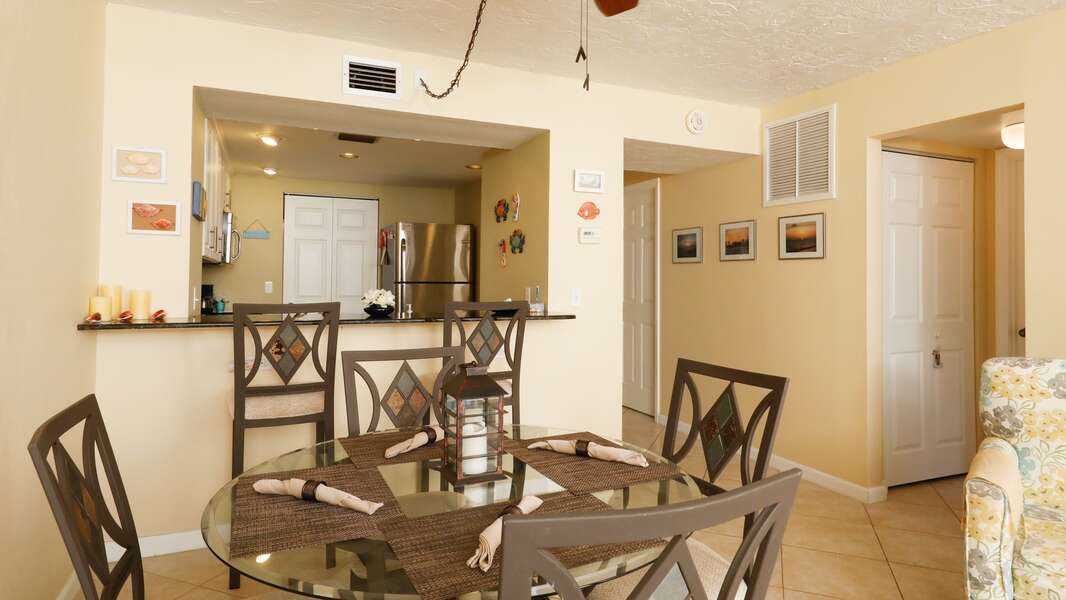 Dining room with seating for 4 at the table and additional seating for two at the breakfast bar
