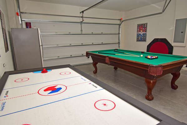 Garage converted to games room with air hockey table, pool table, fridge and table topper for card games.