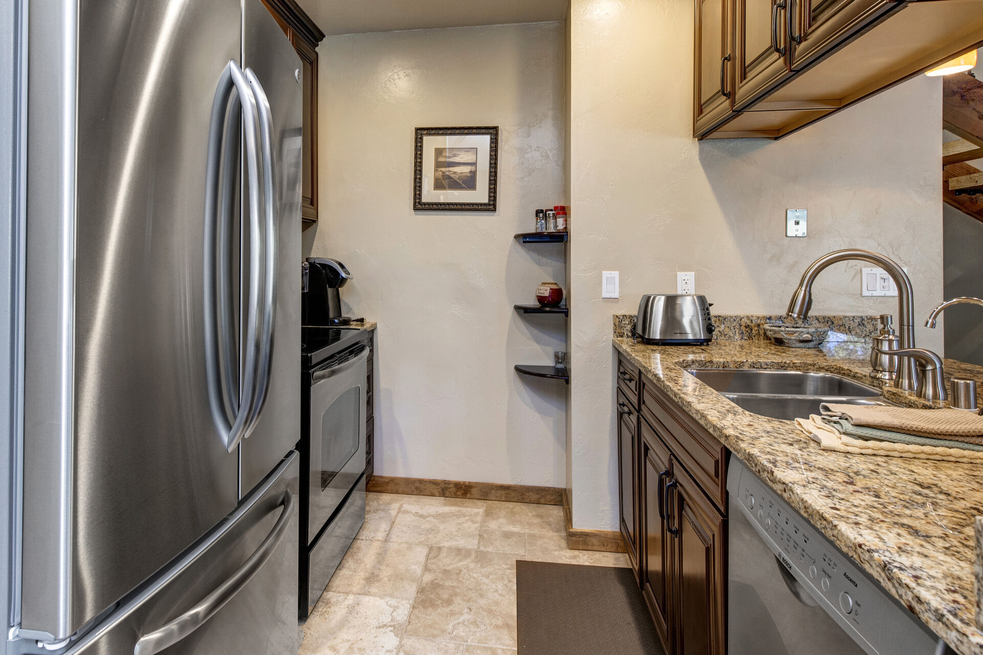 Fully Equipped kitchen with stainless steel appliances, stone countertops and bar seating for up to three