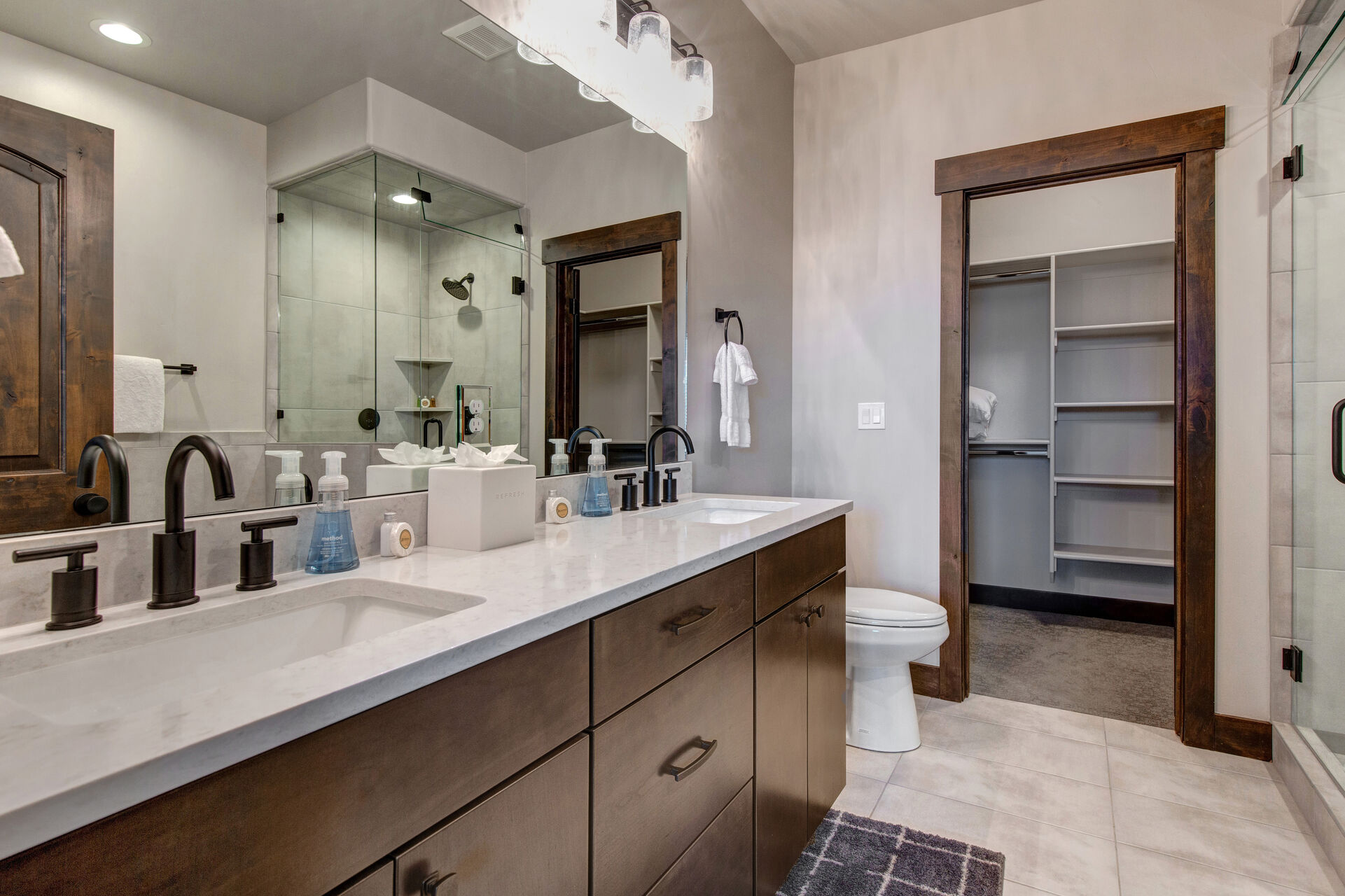 Master Bathroom with walk-in closet, dual sinks, large tiled shower, and separate soaking tub