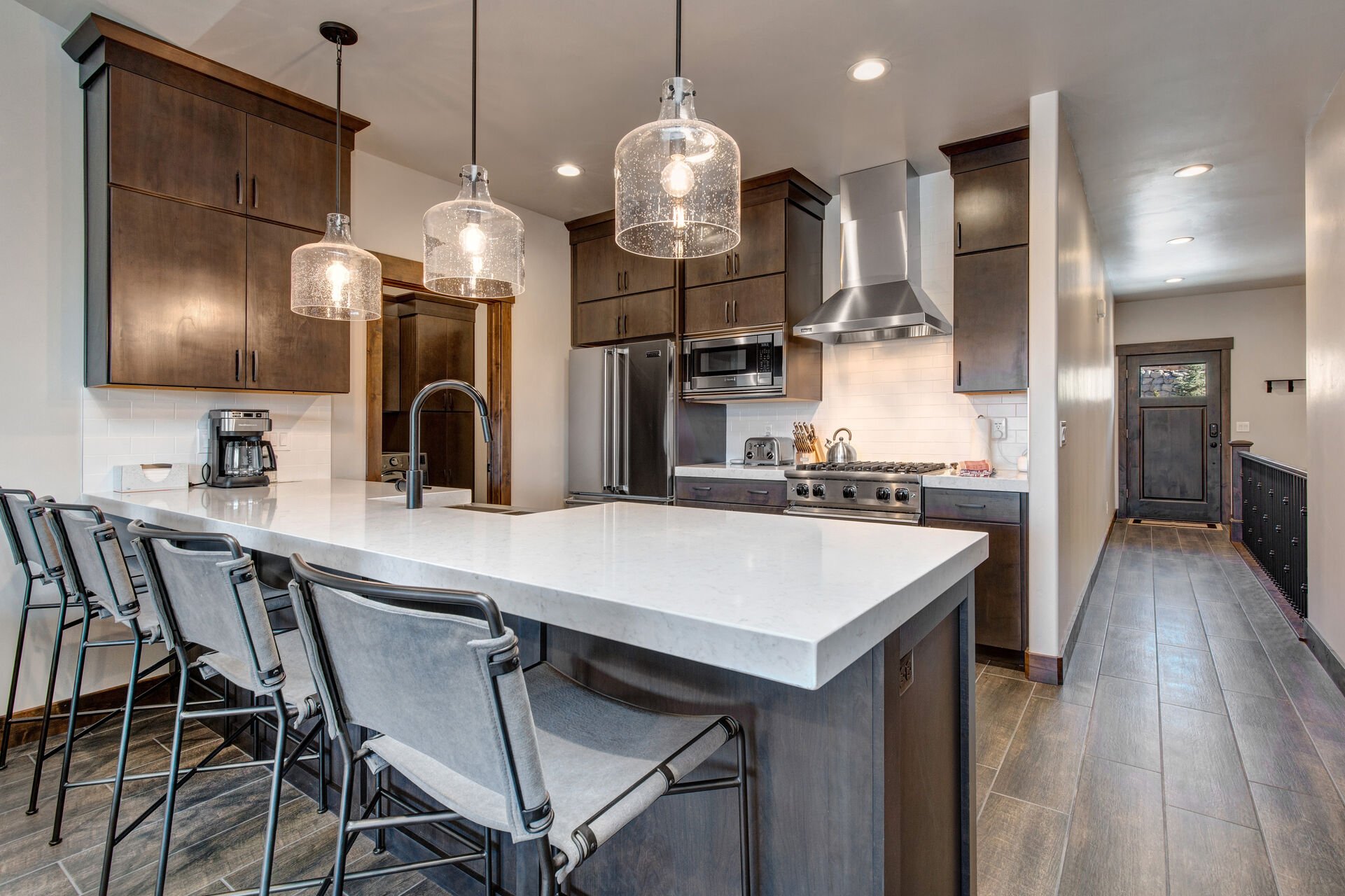 Fully Equipped Kitchen with bar seating for four, stone countertops, and stainless steel Viking appliances