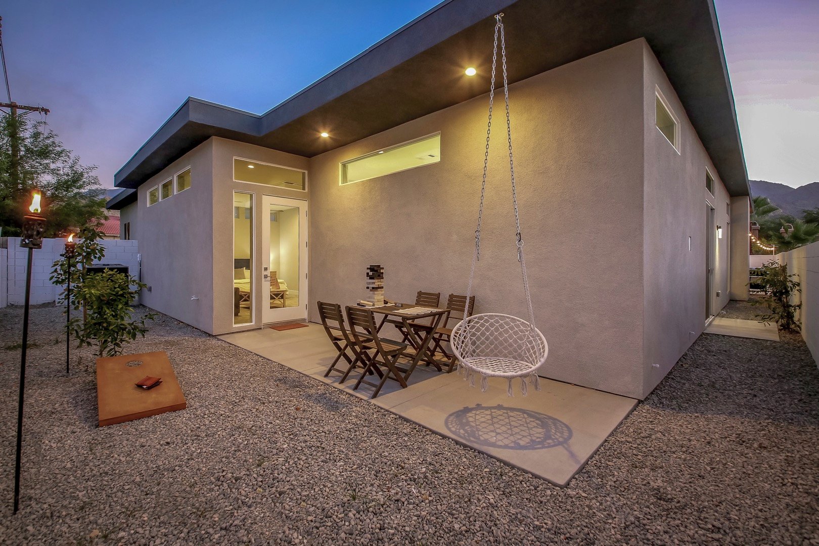 The back patio features a bean bag toss game, swing chair and seating for 4.