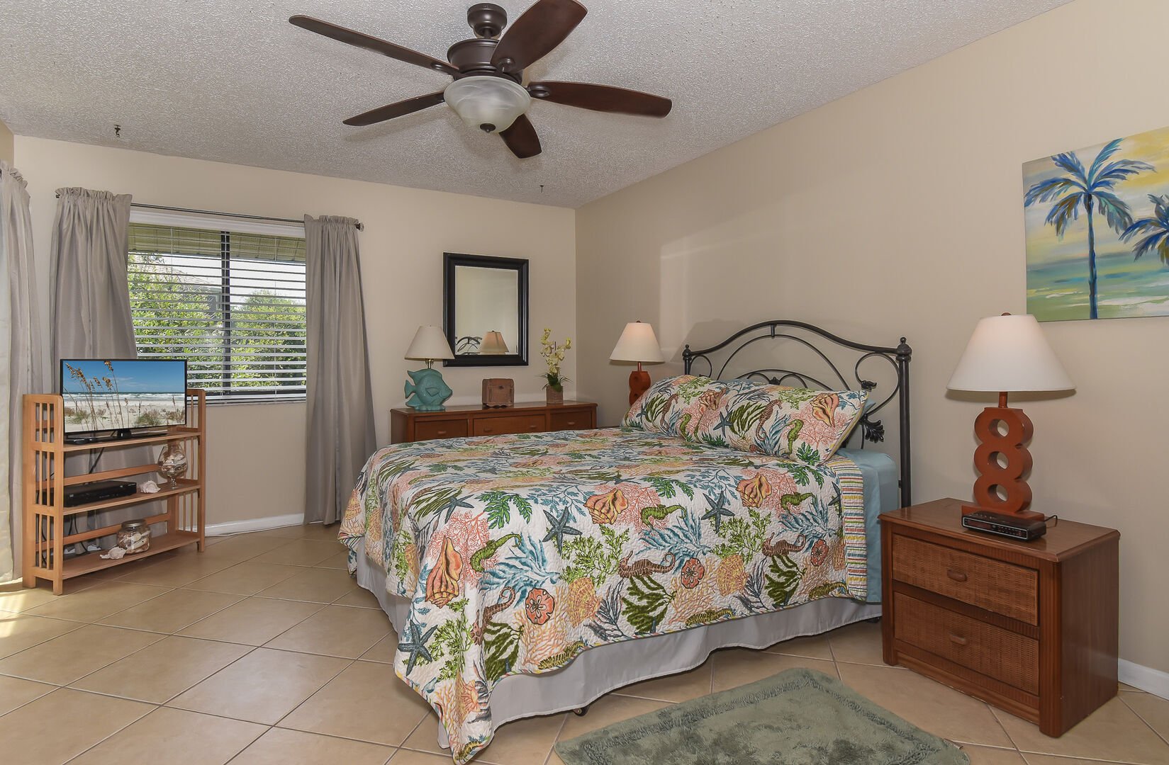 The spacious master bedroom features a king size bed, flat screen TV and sliders to the patio.