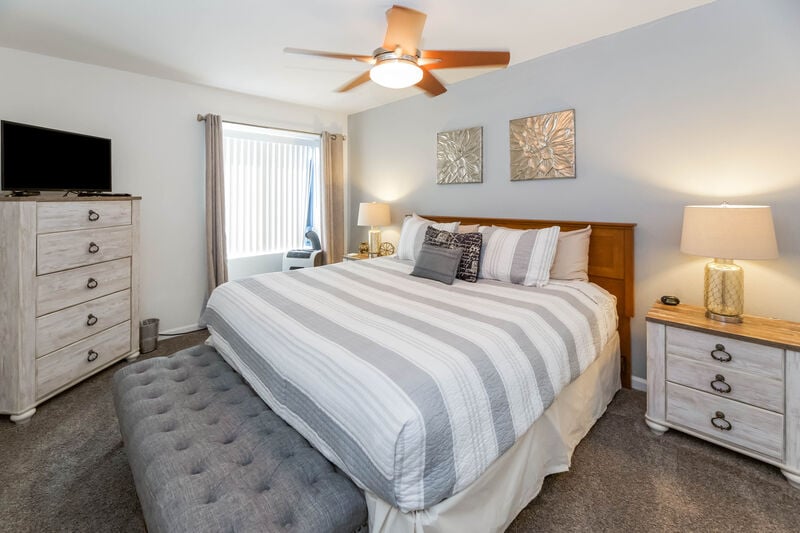 The bedroom features a king-size bed, 32-inch flat-screen tv with cable, and an AC window unit.