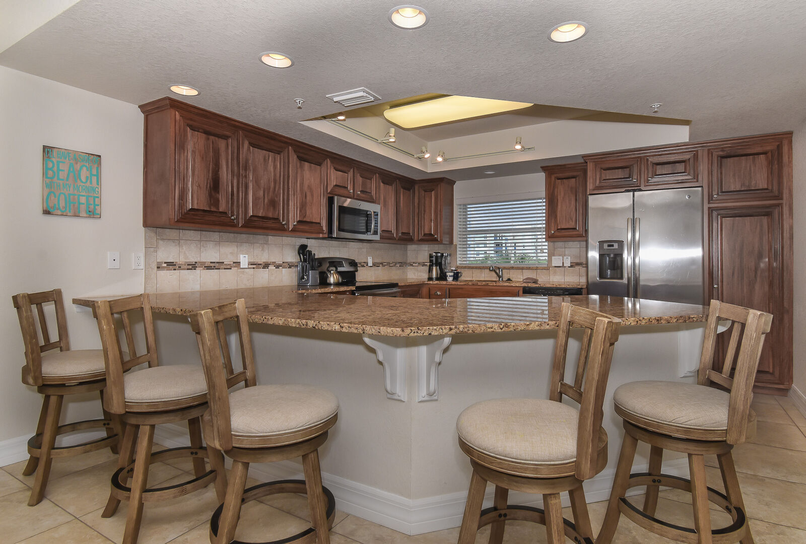 large kitchen and bar stools seating an additional 5