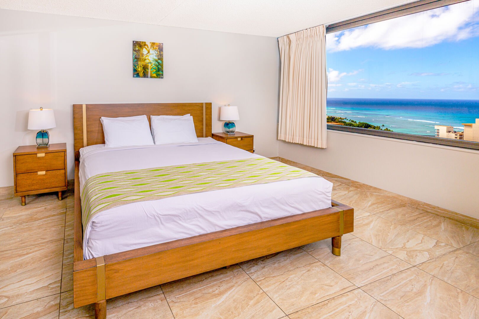 Bedroom with king size bed, tow night stands and ocean view