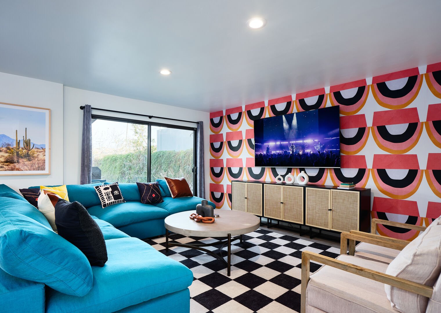 Newly designed living area with designer furnishings, decor, vibrant custom wall paper, and smart TV
