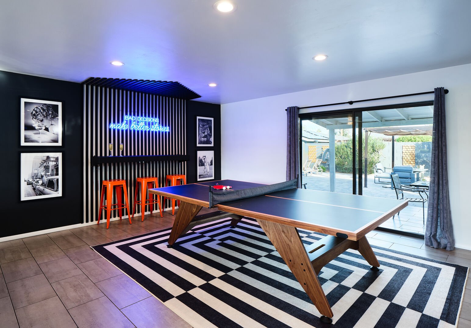 Ping pong table with custom wall bar, neon sign, and designer decor.