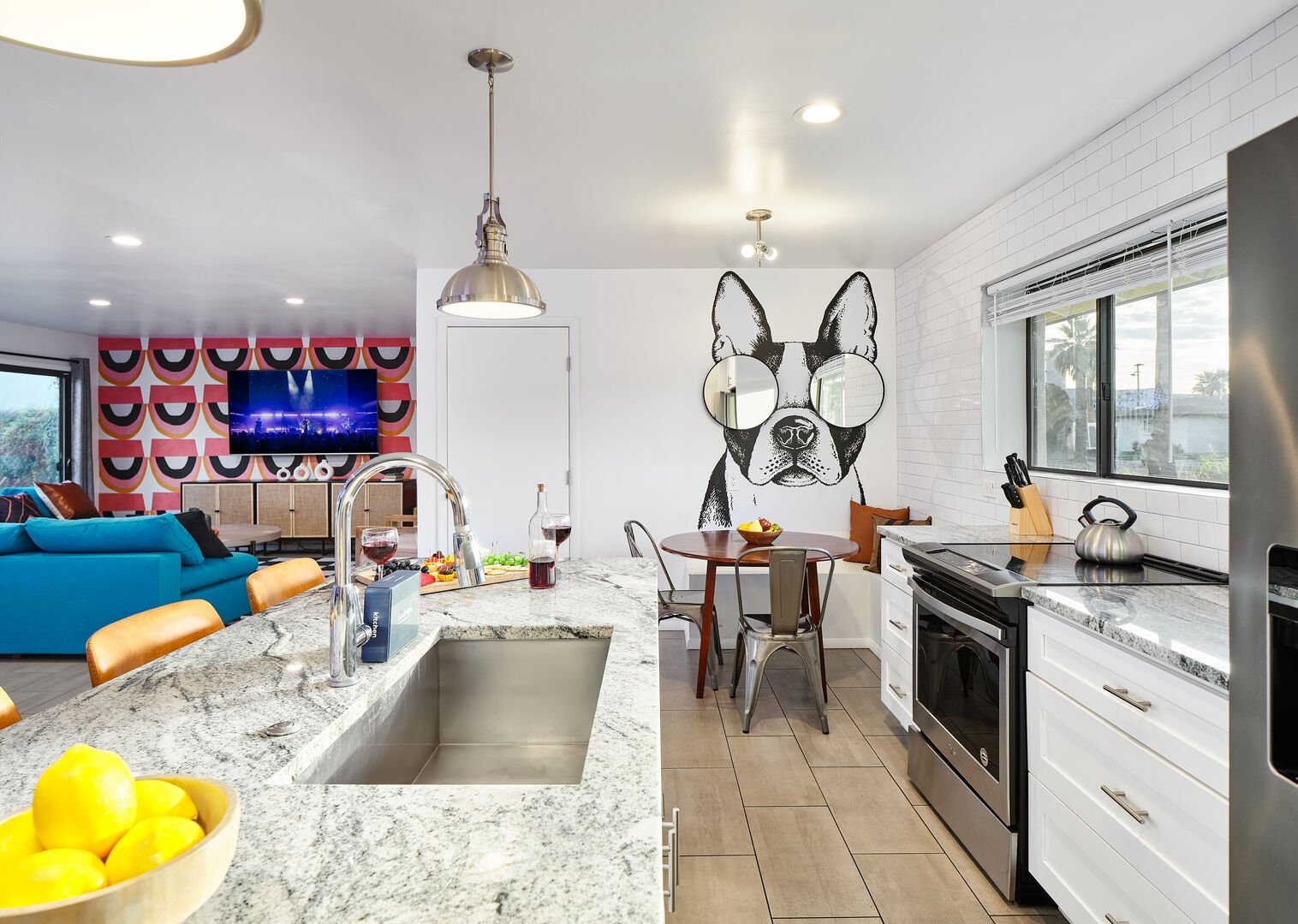 Bright and open kitchen supplied with your basic cooking essentials, stainless steel appliances, breakfast bar seating,  and breakfast nook. Features custom mural Frenchie!
