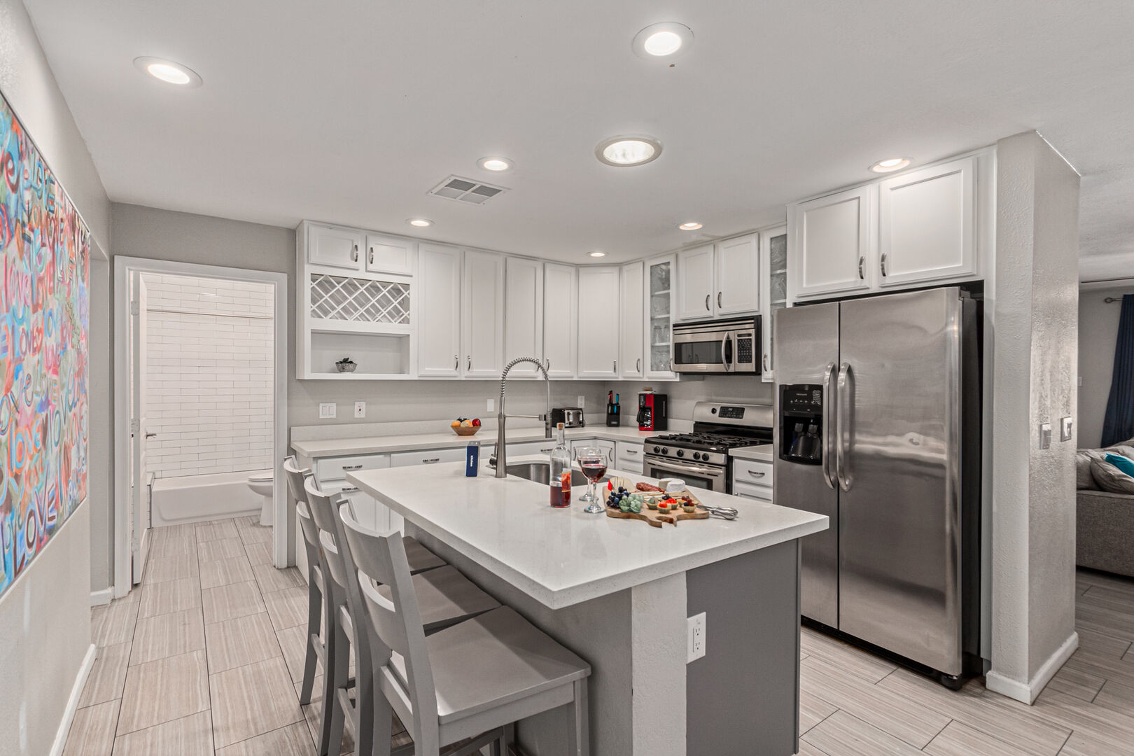 Fully Equipped Kitchen stocked with your basic cooking essentials and stainless-steel appliances, connected to the Dining Room with ample seating.