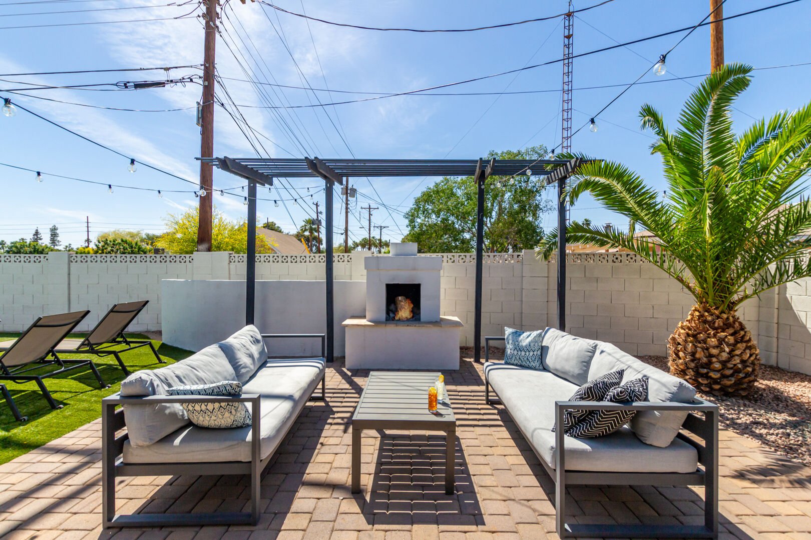 Private Backyard featuring a new mural, sparkling blue pool, fire pit, yard games and a covered patio with outdoor dining and lounging.