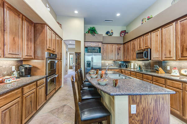 Large Fully Equipped Kitchen with Expansive Granite Countertops and Lovely Wood Cabinetry