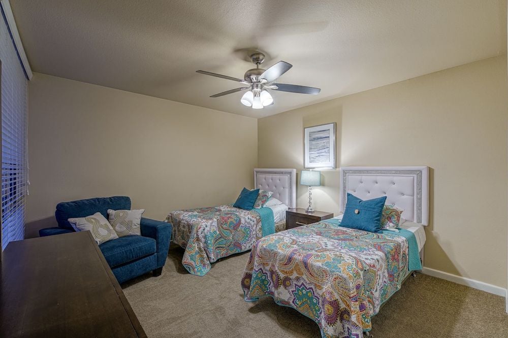 2nd guest bedroom has 2 twin beds with a large comfortable chair and a dresser
