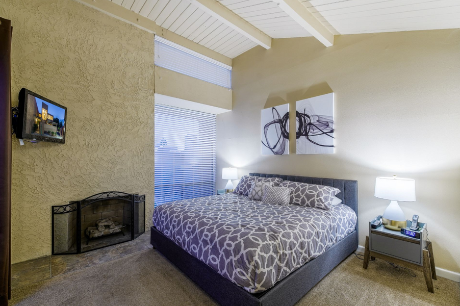 The master bedroom has a king bed with a fireplace, wall-mounted TV and a private balcony