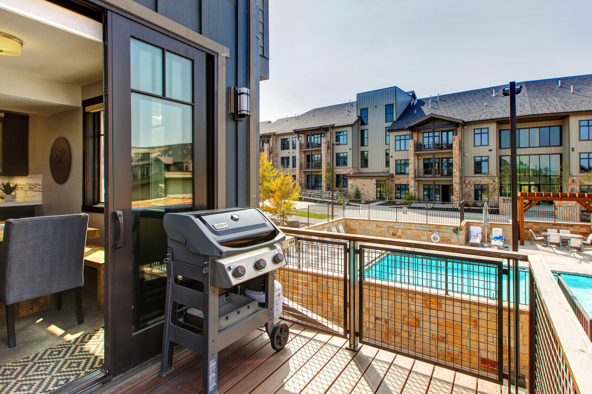 Balcony off the Dining Area with a BBQ Grill that Overlooks the Community Pool