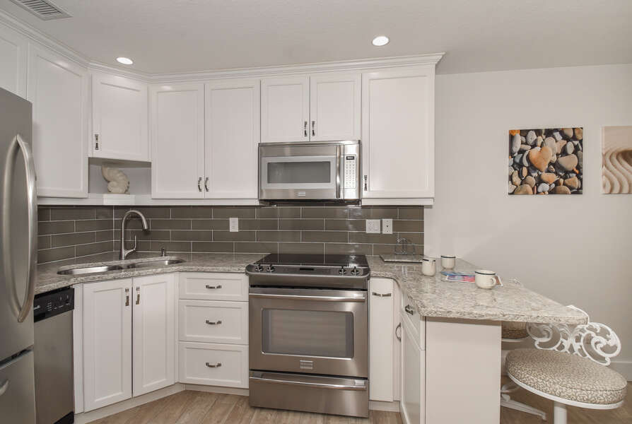 Fully equipped kitchen with barstools seating 2