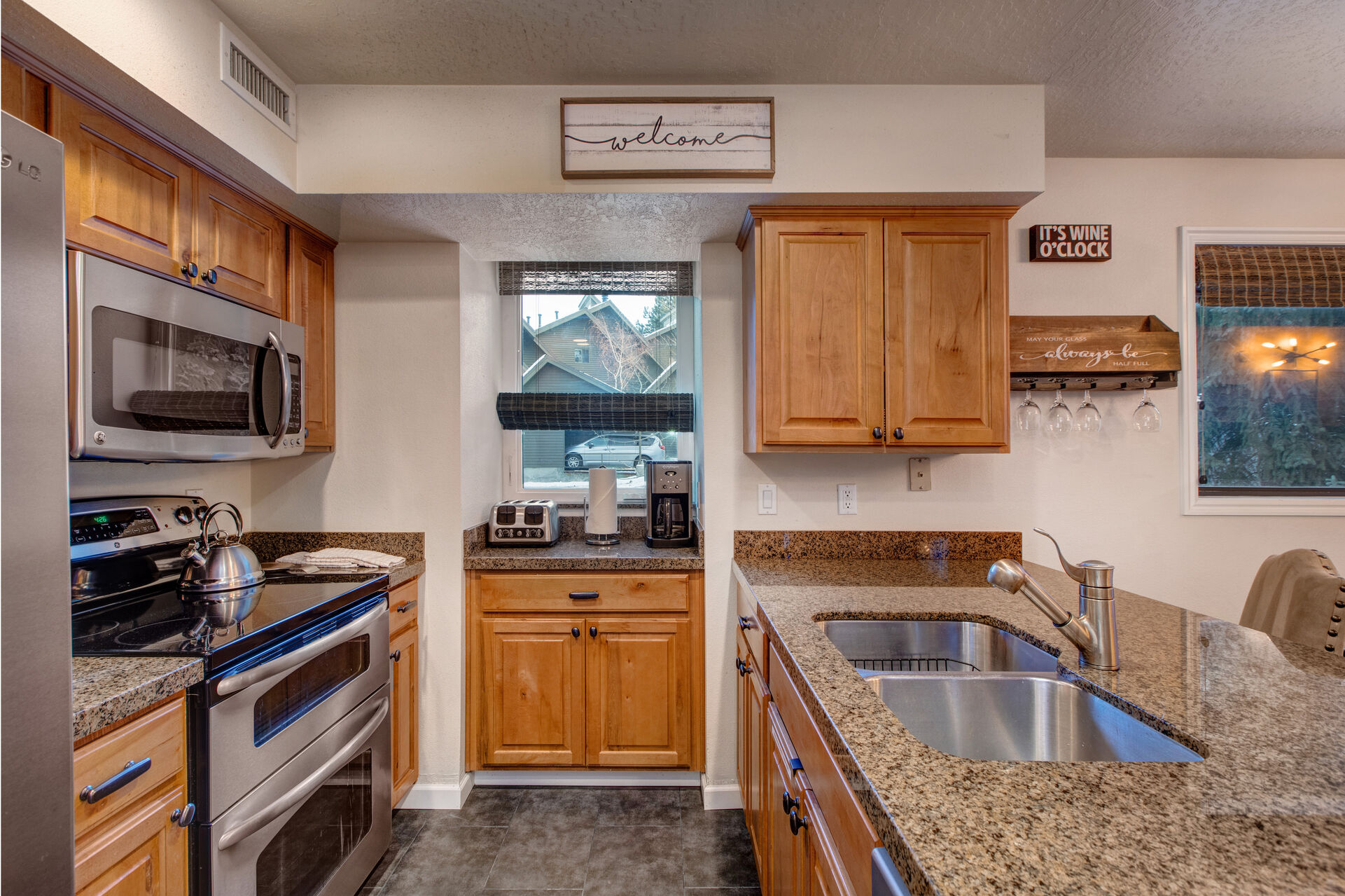 Fully Equipped Kitchen with stone countertops, stainless steel appliances, double oven, and bar seating for three