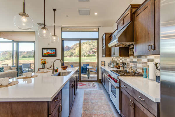 Spacious Gourmet Kitchen with Stone Counters and High-end Stainless Steel Appliances, Including a Wolf Gas Range and a SubZero Refrigerator