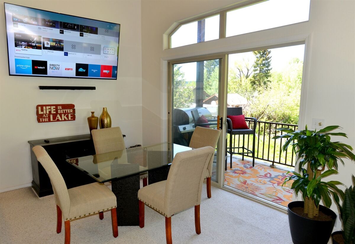 Dining area has big screen TV and balcony access with lake view.