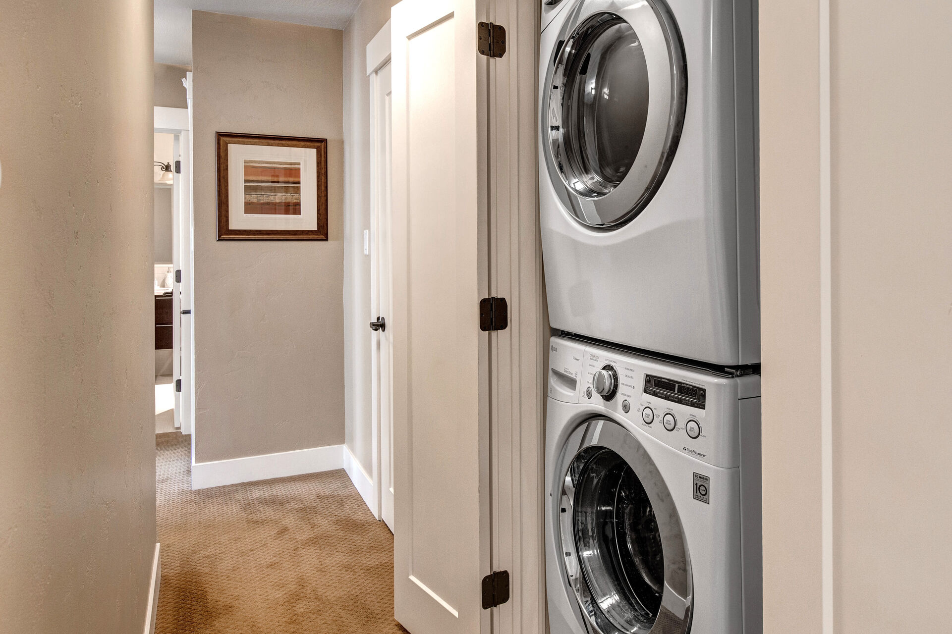 Private stackable laundry unit in hallway closet