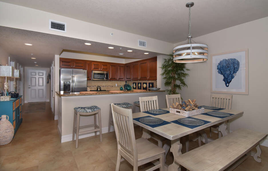 kitchen space, entryway and modern dining room seating within condo rental in new smyrna beach