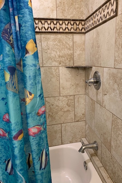 THIS BATHROOM INCLUDES A SHOWER AND A TUB WITH TILE SURROUND