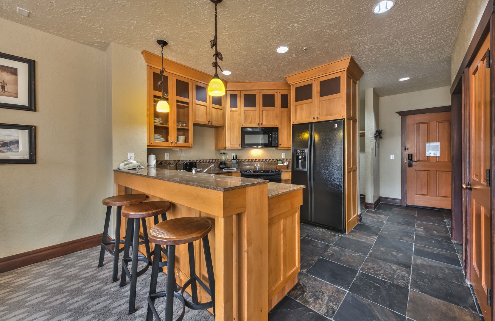 Kitchen is well equipped and includes a breakfast bar