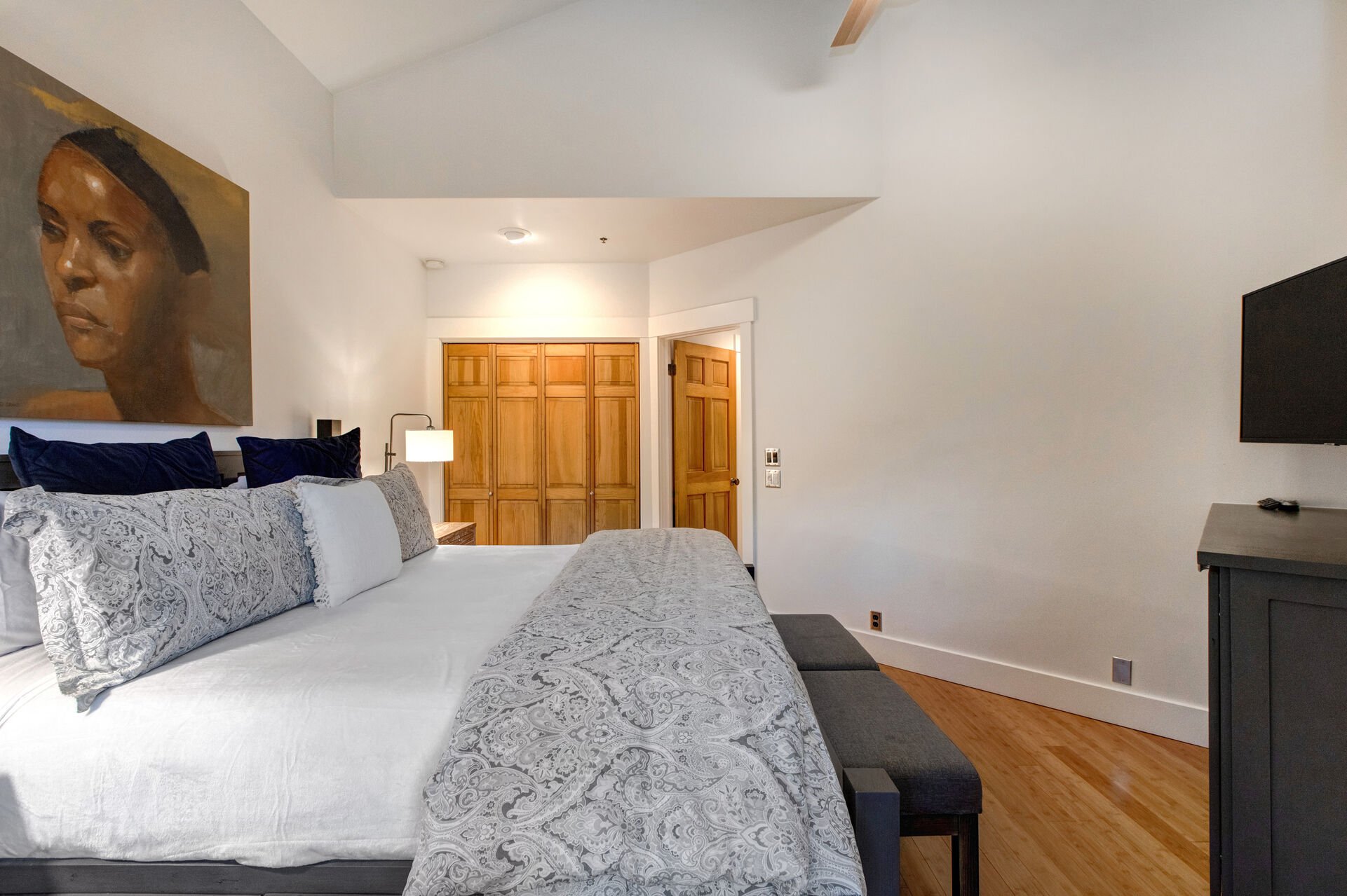 Main Level Master Bedroom with king bed, patio entrance, samsung smart tv, under-bed-storage, and full bath access