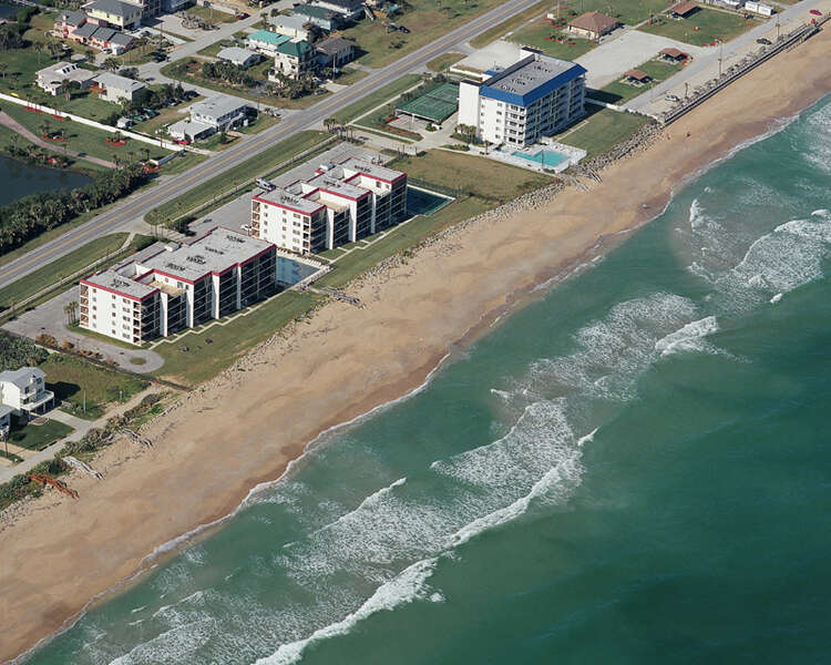 beautiful view of beach and condo complex from the air