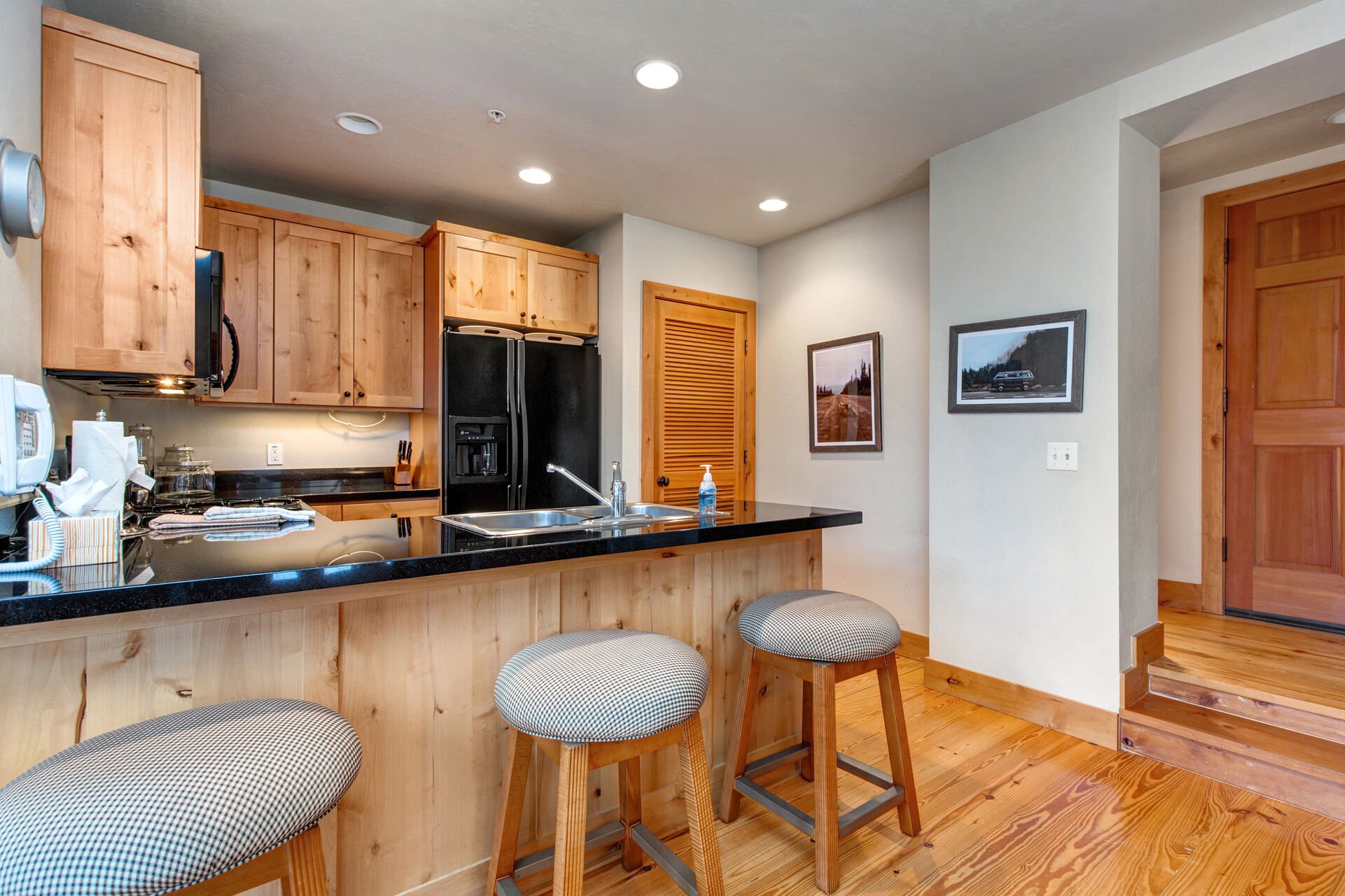 Fully Equipped Kitchen with bar seating for three, beautiful stone countertops, modern appliances, and ice maker