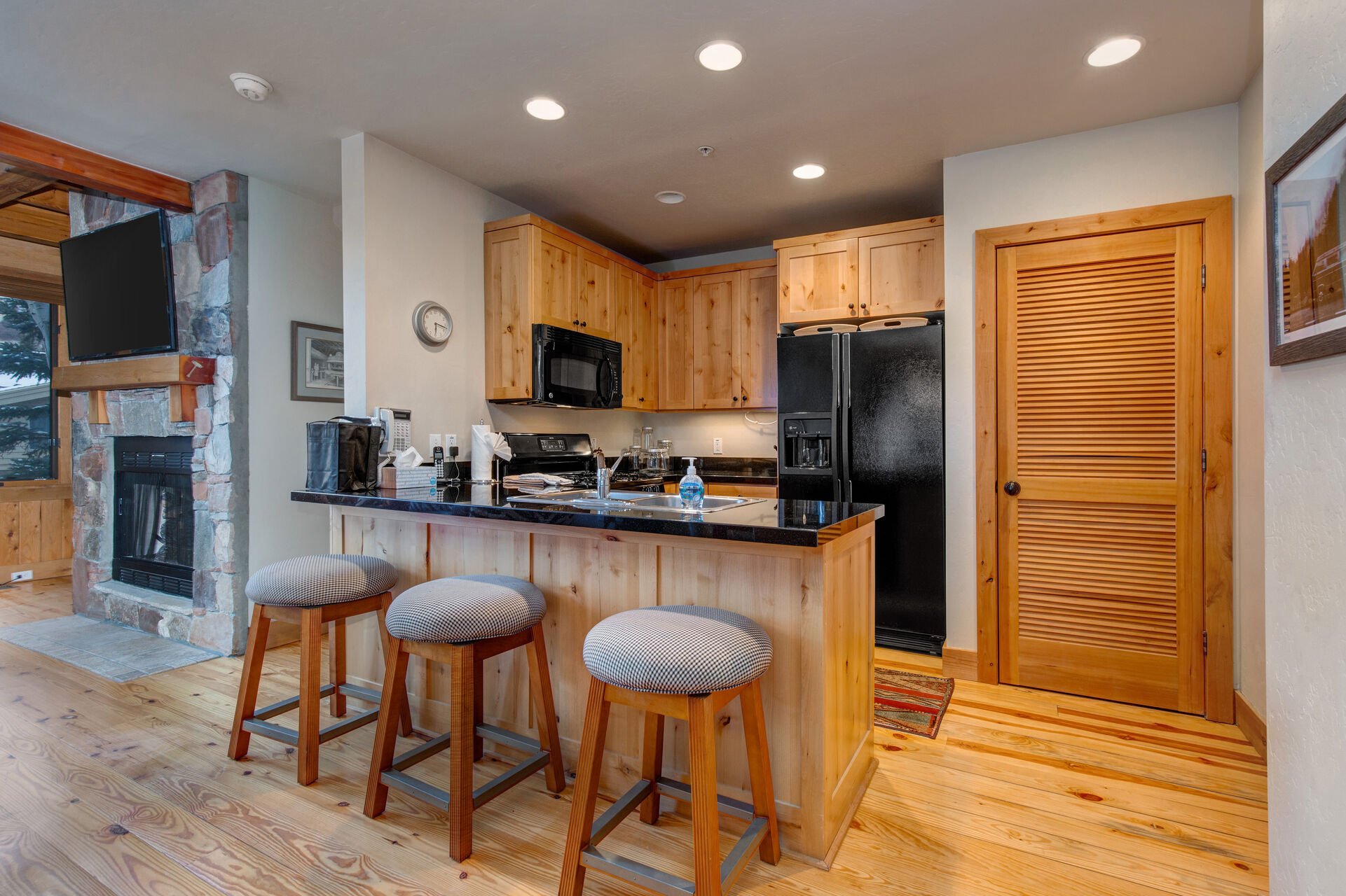 Fully Equipped Kitchen with bar seating for three, beautiful stone countertops, modern appliances, and ice maker