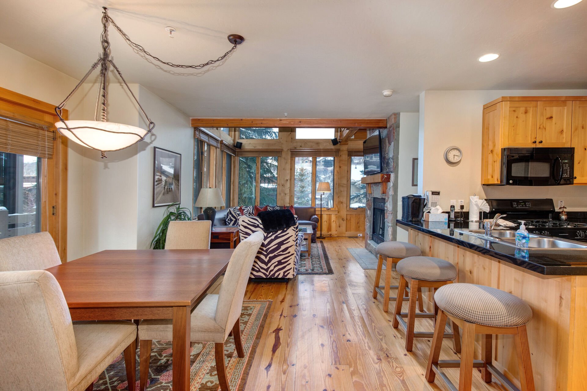 Living Room with vaulted ceilings, stunning windows that allow for an abundance of natural light, leather furnishings, full sofa-bed, gas fireplace, and 55