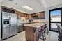 Spacious Fully Equipped Kitchen with Stainless Steel Appliances and Seating at the Breakfast Bar 10