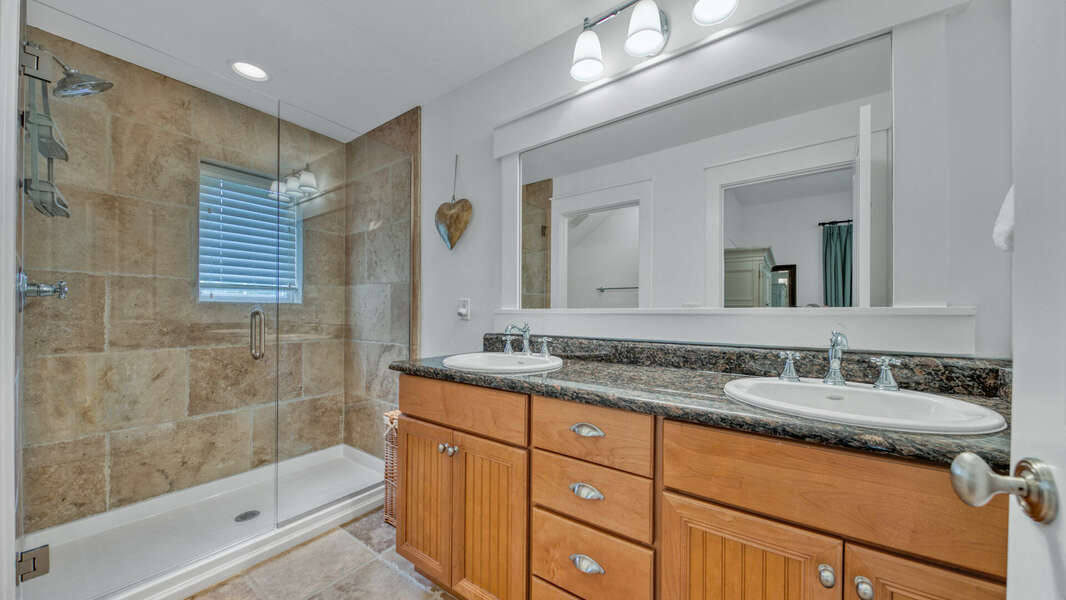 Master bathroom with dual sink vanity and glass door shower.