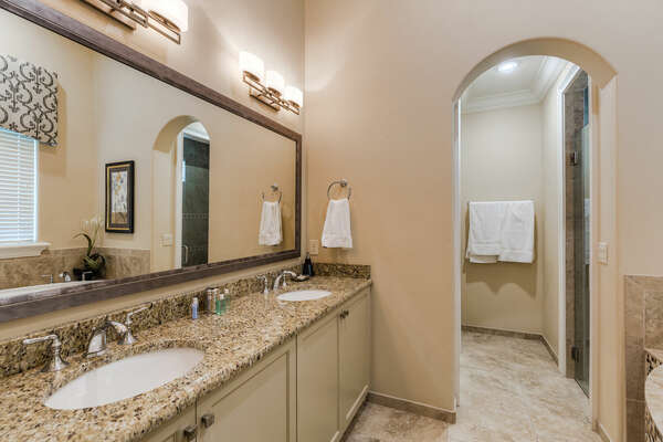 En-suite bathroom has dual sink, garden tub, and glass walk-in shower