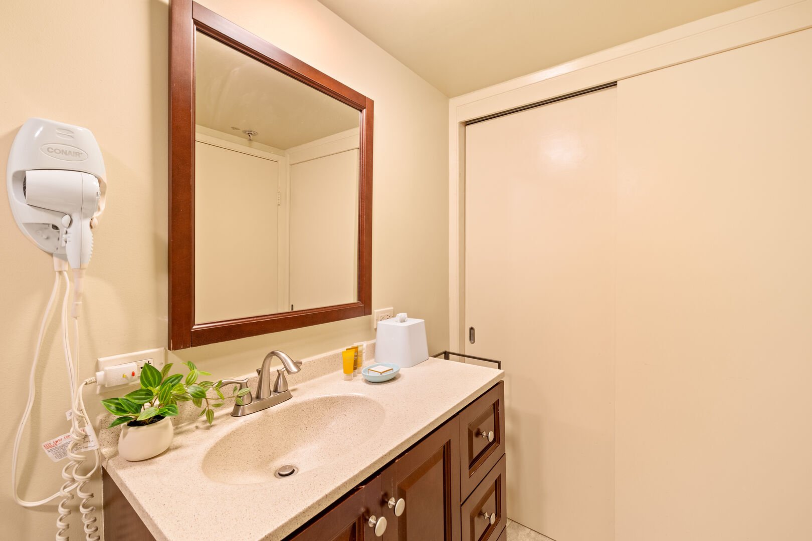 The bathroom has a vanity with a cabinet!