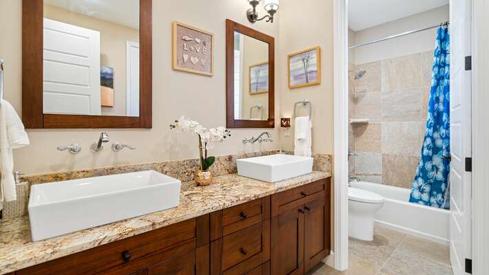 Secondary bathroom with dual sinks and shower/tub combo