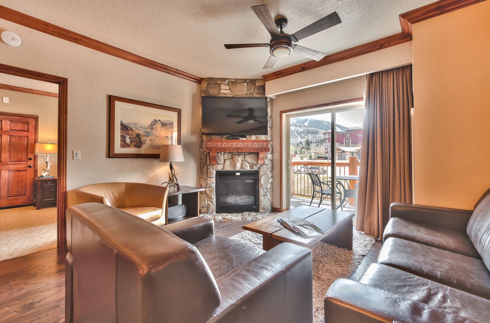 Living room with flatscreen, fireplace, balcony