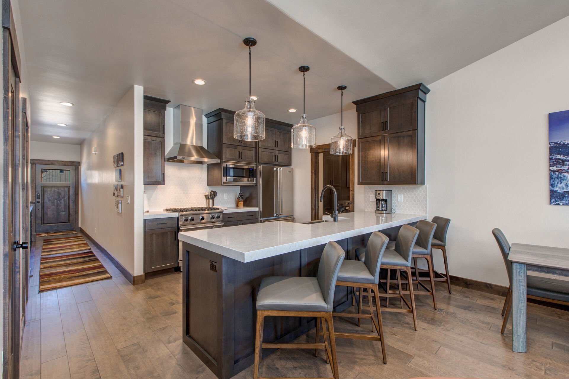 Fully Equipped Kitchen with sleek stone countertops, stainless steel Viking appliances, ample counter-space, and bar seating for five