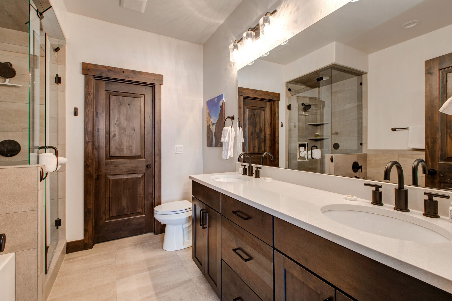 Master Bathroom with large tiled shower which also serves as a steam shower, separate soaking bathtub, and dual vanities