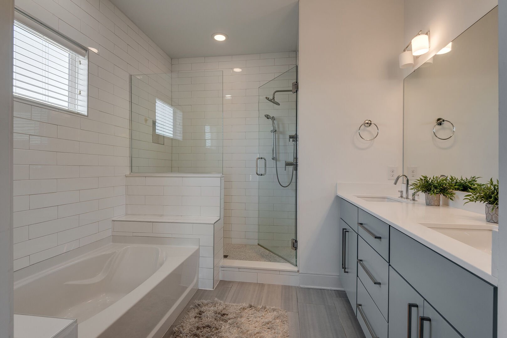 Master bathroom with double sink vanity, walk in closet, soaker tub and separate shower