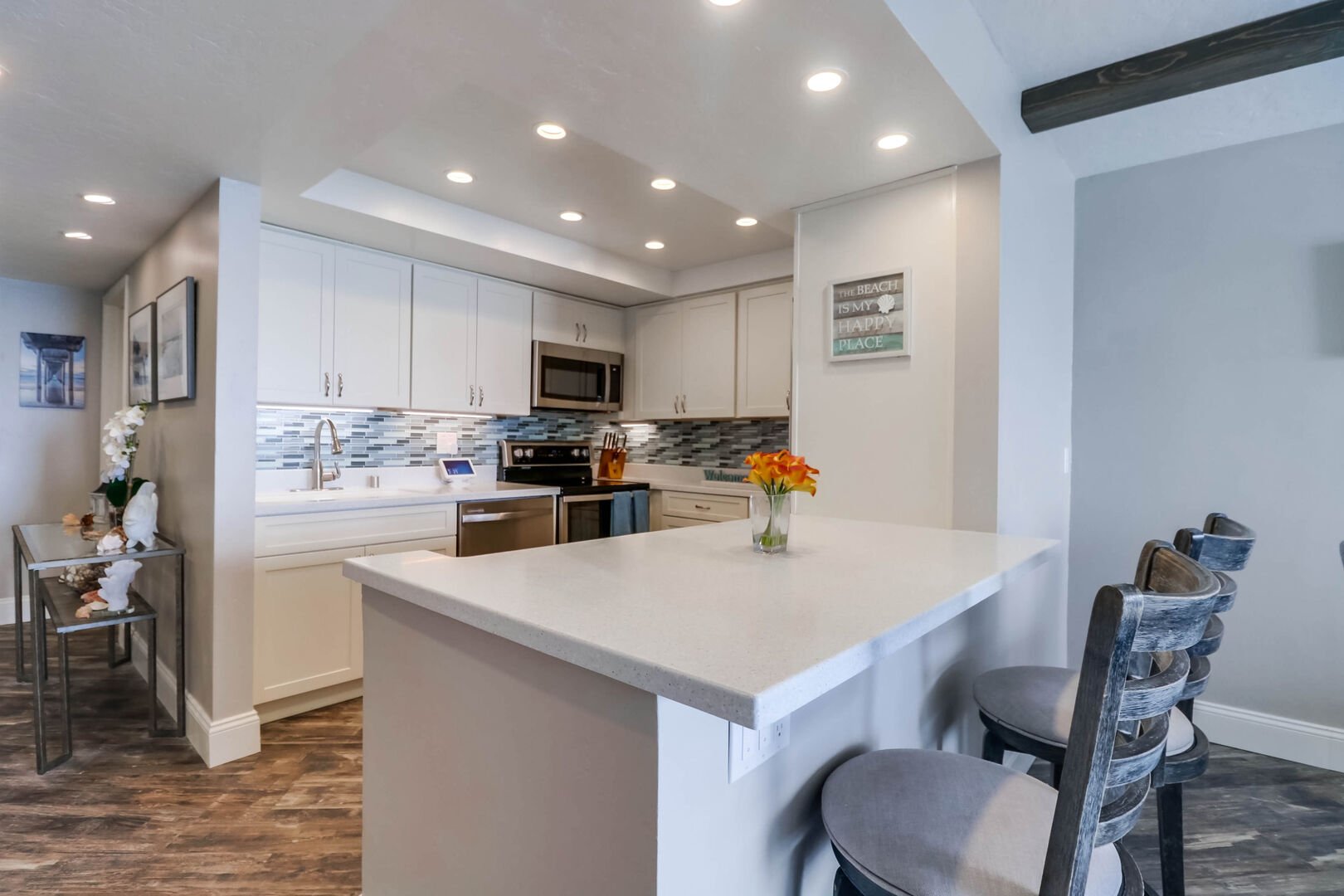 Kitchen with quartz countertops, stainless steel appliances, Keurig coffee maker, blender, toaster, recessed lighting