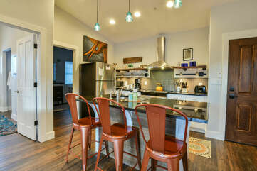 Kitchen with Island, Stools, Refrigerator, Microwave, and the Coffee Maker.